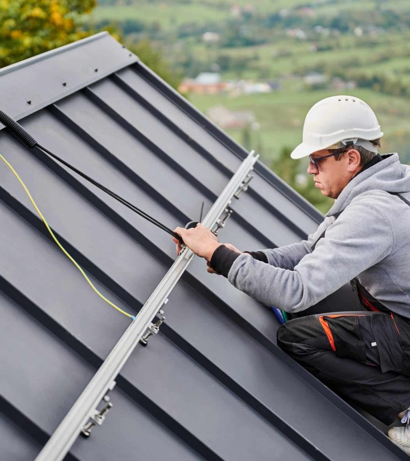 Man,Roofer,Prepearing,For,Mounting,Photovoltaic,Solar,Modules,On,Roof